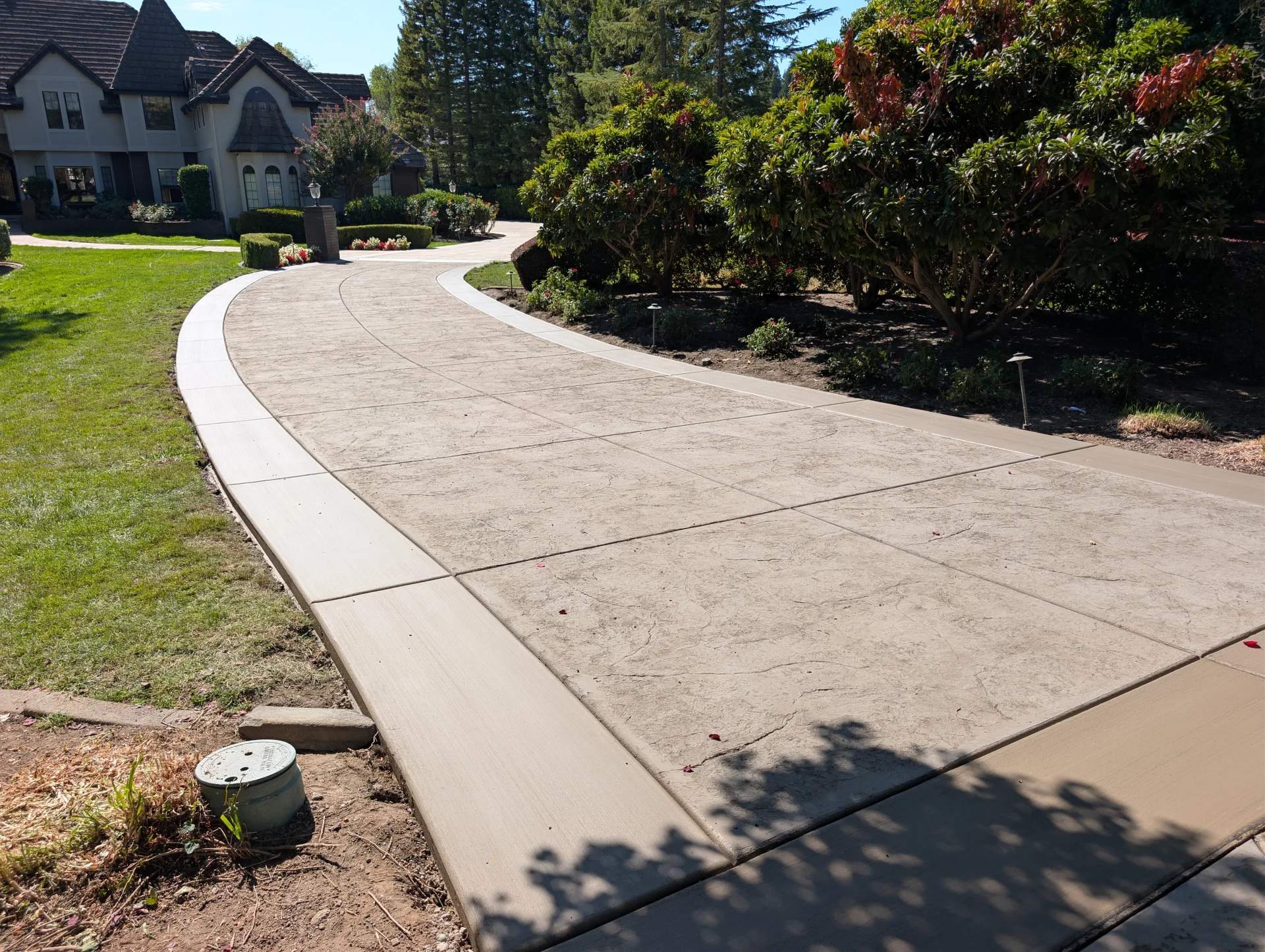 Completed curved stamped driveway leading toward the Granite Bay home